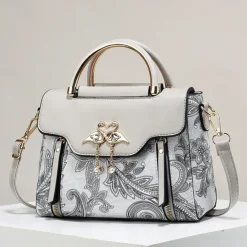 Women's Elegant Swan Pendant Handbag - Black and White Paisley Design with Gold Accents and Adjustable Strap