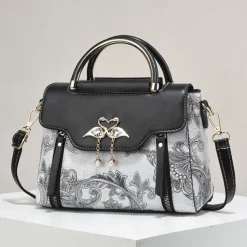 Women's Elegant Swan Pendant Handbag - Black and White Paisley Design with Gold Accents and Adjustable Strap